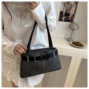 Close-up of matte dark gray tote bag with black leather buckle strap and silver hardware