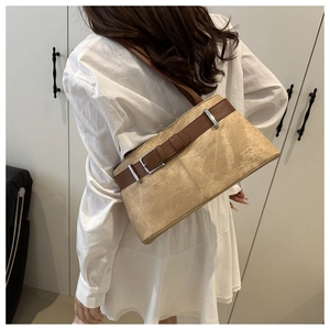 Detail of retro suede tote bag with brown leather straps and metal buckle accent