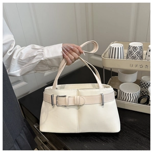 Detail of cream leather tote bag with silver buckle and decorative waist belt strap