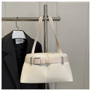 Close-up of cream white faux leather tote bag featuring decorative buckles and silver hardware