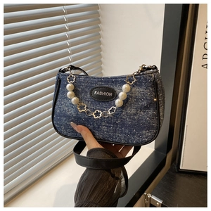 Detail of denim texture underarm bag with pearl flower chain and fashion leather label