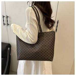 Brown monogram tote bag with large capacity and letter print worn by a model in detail