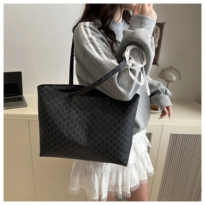 Detailed view of black tote bag with M-letter print pattern and long shoulder strap