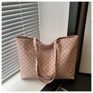 Detail of large tote bag with repetitive M letter pattern and sturdy double handles