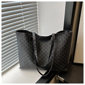 Detail of large tote bag with M-letter jacquard pattern and slim shoulder straps