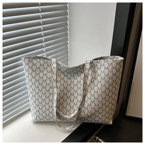 Macro shot of large tote bag with gray letter M patterns on thick canvas material