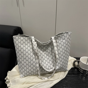 Large capacity off-white tote bag with grey 'M' pattern on black wooden table