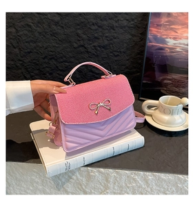 Détail du sac rose avec matelassage en V et fermoir élégant en forme de nœud métal