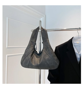 Detail of dark grey tote bag with geometric stitching and matte faux leather texture