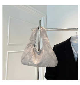 Macro detail of high-quality light grey leather stitching on vintage hobo tote bag