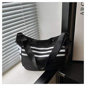 Détail du sac cabas en toile noire avec rayures blanches et imprimé d'une lettre P