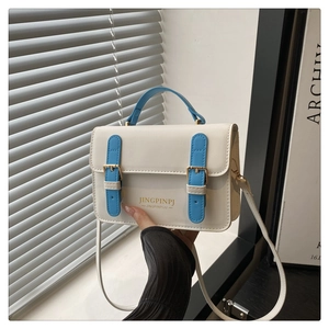 Dettaglio borsa quadrata beige in pelle PU con cinturini blu e fibbia metallica