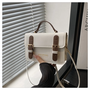 Dettaglio mini borsa a tracolla vintage in pelle crema con fibbie in cinturino marrone