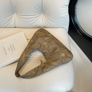 Vintage dark brown oversized pleated tote bag in soft leather on a minimalist cream sofa