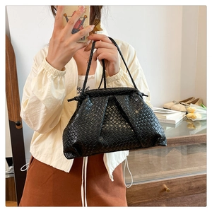 Detail of hand-woven black cloud bag featuring premium Intrecciato texture and soft folds