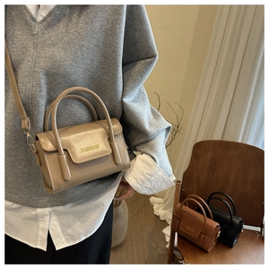 Model trägt eine Vintage khakifarbene quadratische Umhängetasche mit Fashion-Gravur