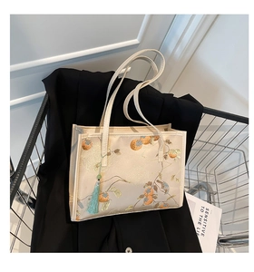 Detailed embroidery of persimmon fruits and branches on the elegant beige tote bag