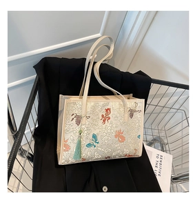 Detail of Chinese style tote bag featuring carp patterns and green tassel ornament