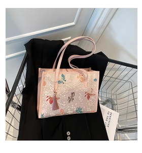 Detail of light pink tote bag with floral embroidery and purple tassel charm