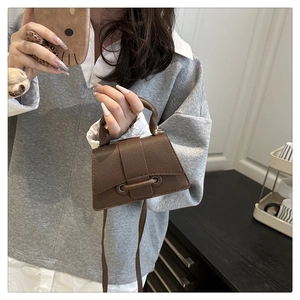Close-up of a brown litchi textured mini trapezoid handbag with drawstring detail