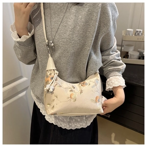 Detailed view of half-moon silk handbag with exquisite flower and bird embroidery