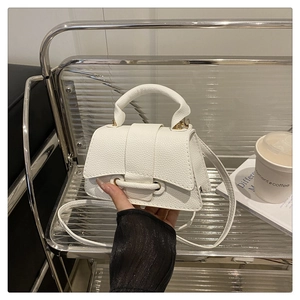 Detailed close-up of a white mini hourglass handbag with litchi texture and gold hardware