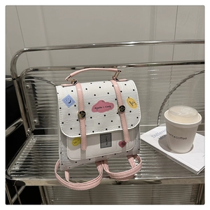 Polka dot backpack with pink handles on a silver cart with lifestyle coffee props