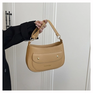 Detailed shot of caramel crescent bag featuring pebbled leather and gold fashion studs