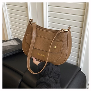 Detailed macro view of the brown lychee grain leather crossbody bag and gold hardware