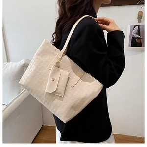 Detail view of beige tote bag with textured pattern and matching mini storage pouch