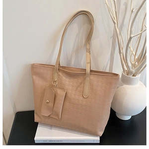 Detail of apricot tote bag featuring houndstooth texture and hanging mini pouch