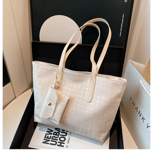 Close-up of cream houndstooth embossed leather tote bag with matching coin purse detail
