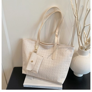 Detail view of cream tote bag with woven texture and matching mini pouch set