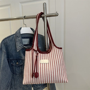 Large striped canvas tote bag with red leather handles and vertical stripes