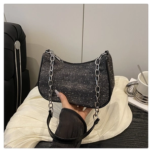 Close-up of dark grey denim texture bag with silver rhinestones and metal chain strap