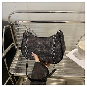 Détail du sac croissant en denim gris foncé avec strass et bandoulière en chaîne argentée