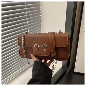 Vue détaillée du sac à bandoulière en cuir mat marron avec un nœud en métal argenté