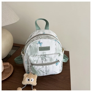 Nahaufnahme des weißen Mini-Rucksacks mit grünen Bambusprints und Schmetterlingen