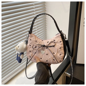 Pink pleated handbag with black bows, heart pendant, and plush bear charm detail