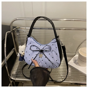 Detail of blue striped fabric tote bag with black leather trim and cute bear charm