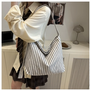 Detailed texture of large vertical striped canvas tote bag in a casual lifestyle setting