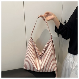 Detailed macro view showing the red and white vertical striped canvas fabric texture of tote bag