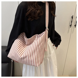 Detail of red and white striped canvas hobo bag with adjustable wide shoulder strap