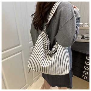 Detail of blue and white striped canvas tote bag showing the side drape and texture