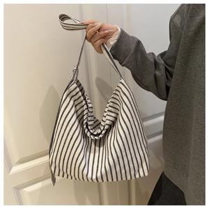 Close-up of blue and white vertical striped canvas tote bag with wide shoulder strap