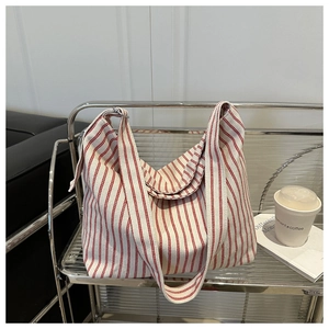 Red and white striped canvas tote bag displayed in a stylish urban lifestyle setting
