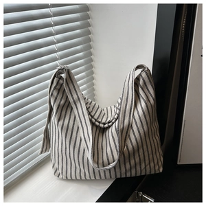 Close-up of minimalist striped canvas tote bag with black vertical stripes on a soft hobo frame