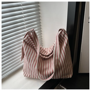 Detail of red and white striped canvas tote bag texture with wide adjustable shoulder strap