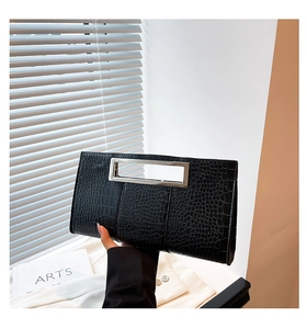 Close-up of black crocodile pattern faux leather clutch with silver metal handle