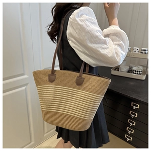 Macro detail of hand-woven straw tote texture with premium stitched brown leather handles